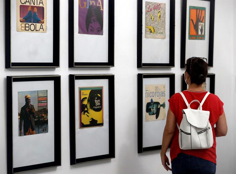 Una visitante observa las caratulas de diversos discos